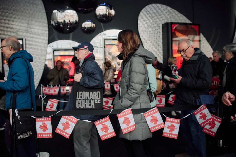 People standing in line for a film behind Canadian flag bunting at the Scotiabank Theatre in Toronto.